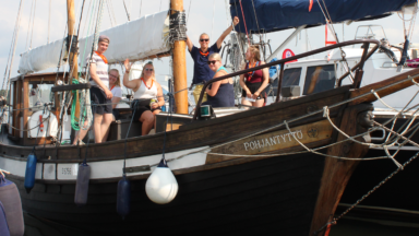 Kuvassa on nuoria partiolaisia Pohjantyttö-purjealuksen kannella.