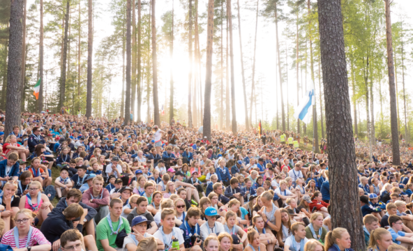 Tuhansia partiolaisia istuu metsänrinteessä