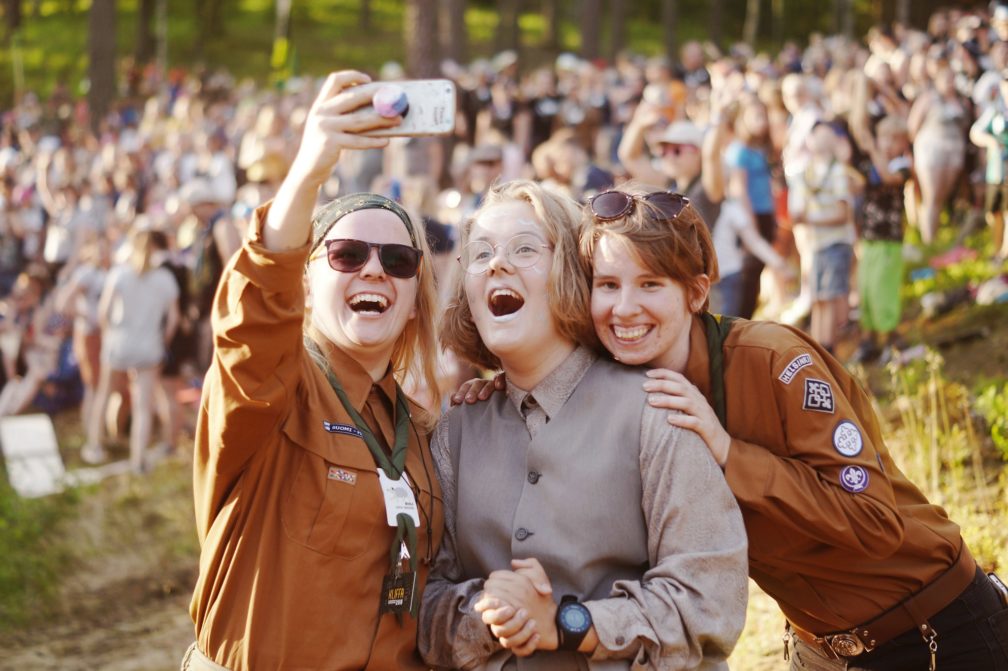Kuvassa iloisia partiolaisia ottamassa selfietä