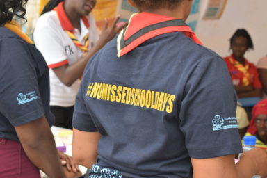 Kuvassa näkyy naisen T-paidan takaosa, jossa lukee projektin nimi #NoMissedSchooldays.