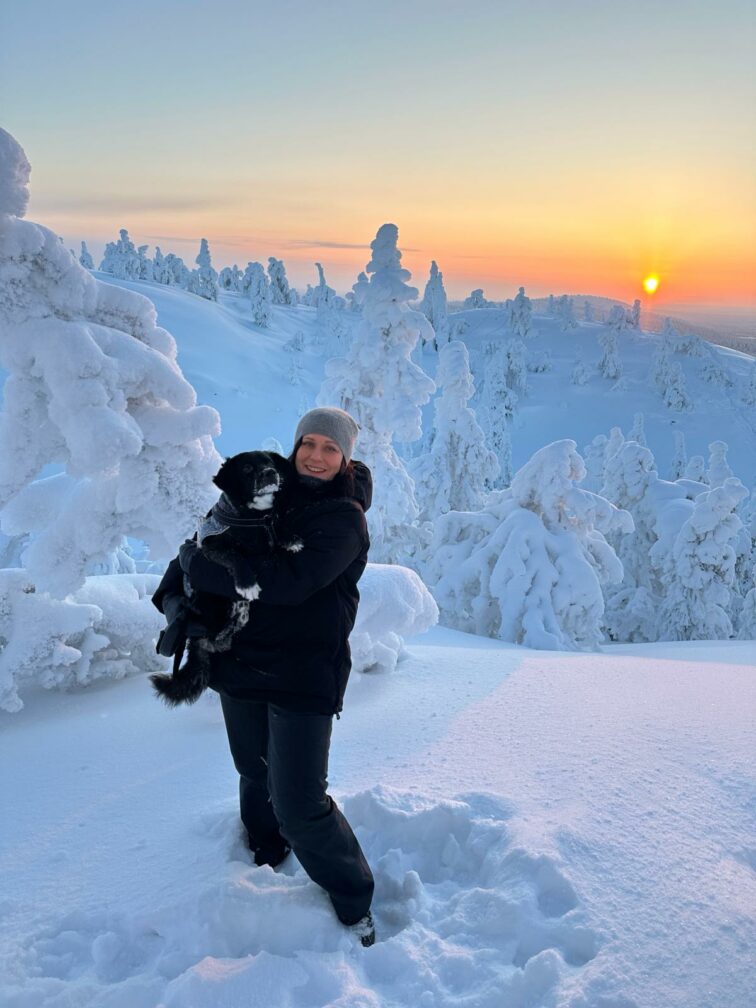 Talousjohtaja Pia Schildt talvimaisemissa koiran kanssa.
